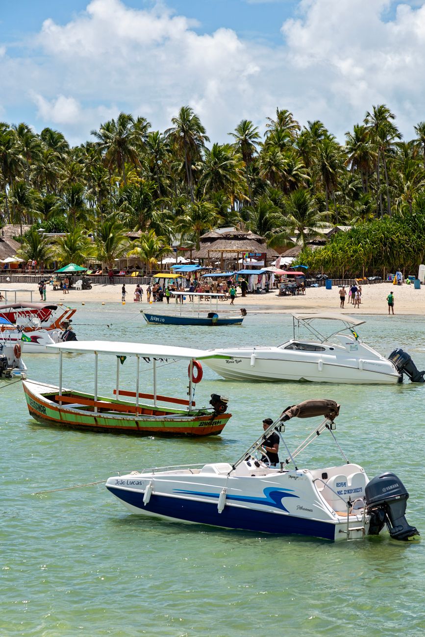 tropical beach with boats and palm trees
